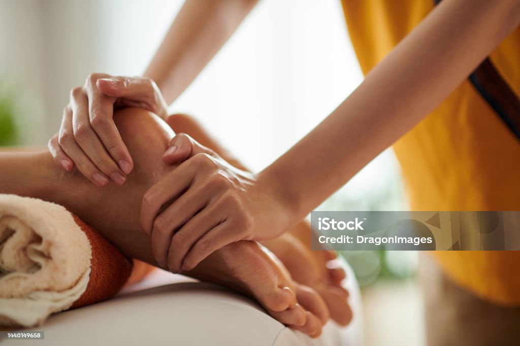 Woman Receiving Feet Massage Closeup image of woman receiving relaxing feet massage with oils Massaging Stock Photo