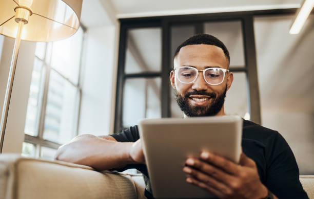 black man, tablet and smile for social media post, shopping online or browsing internet creative content at home. young africa american happy, relax and calm on tech digital app on device - man stockfoto's en -beelden