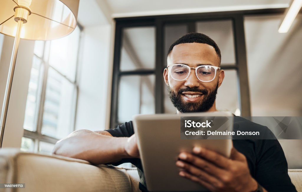 Black man, tablet and smile for social media post, shopping online or browsing internet creative content at home. Young africa american happy, relax and calm on tech digital app on device People Stock Photo