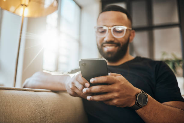 istock Relax, texting and black man with phone on sofa enjoy weekend, break and free time at home. Online, social media and young guy typing, chatting and on smartphone for internet, media and web content 1440149718