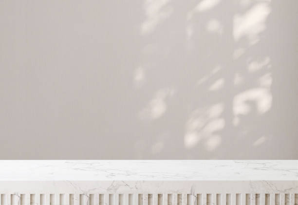 istock White marble tabletop or countertop in modern and minimal wall room with dappled sunlight and tree shadow from window at home 1440150907