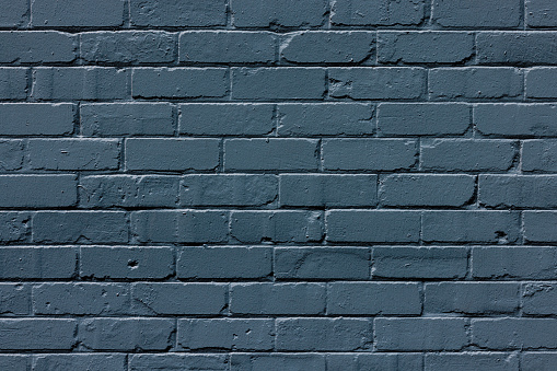 Section of an old brick wall freshly painted blue.