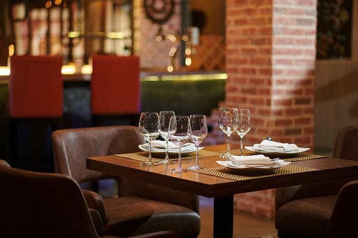 Plates, napkins, silverware and wine glasses on restaurant table