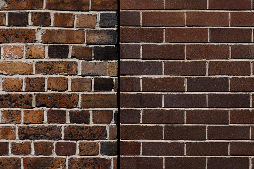 Section of two old brown brick walls joined together.