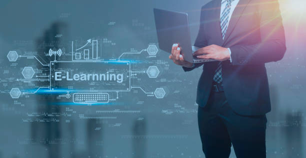 istock Businessman in black suit holding laptop and virtual screen on blue background, e-learning education Internet Technology Webinar Online Courses concept. 1440162094