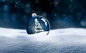 雪の中の透明なガラスのクリスマスボール