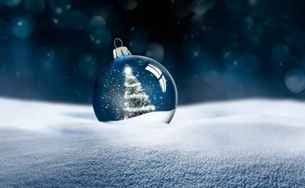 Photo of Transparent glass Christmas ball in snow
