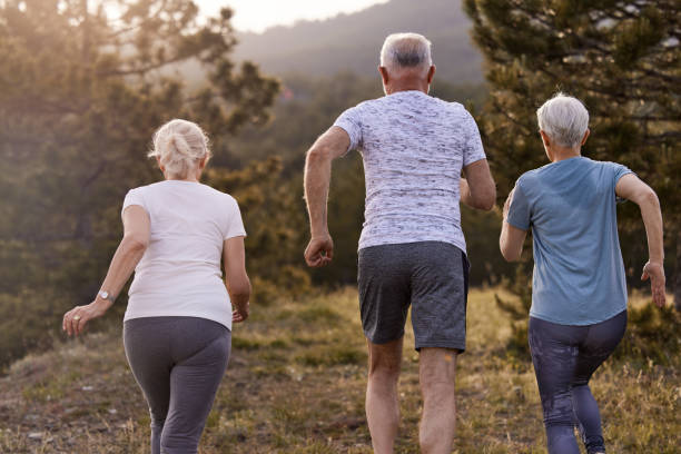 istock Back view of senior athletes running during sports training in nature. 1440168942