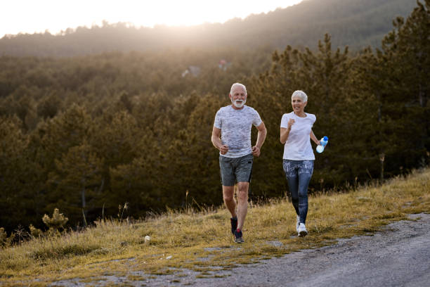 istock Happy senior couple jogging in nature. 1440169956