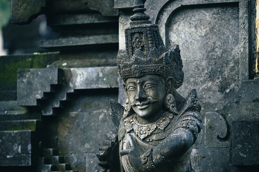 Traditional sculpture made of stone seen in the jungle of the Bali island, Indonesia.