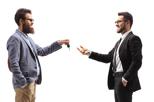 Bearded man giving car keys to a businessman isolated on white background