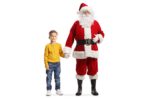 Full length portrait of santa claus holding hands with a boy isolated on white background