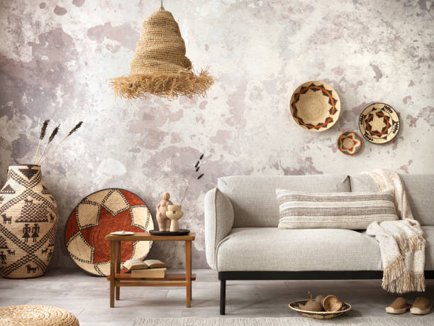 istock Interior design of ethnic composition living room interior with grey sofa, colorful wicker, boho straw lamp, gray concrete wall, bench and personal accessories. Home decor. Template. 1440179040