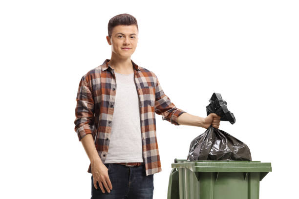 istock Smiling young man throwing a waste bag in a bin 1440179633