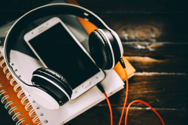 istock Headphones with note book and smartphone on wood table  background Vintage tone processing 1440180875