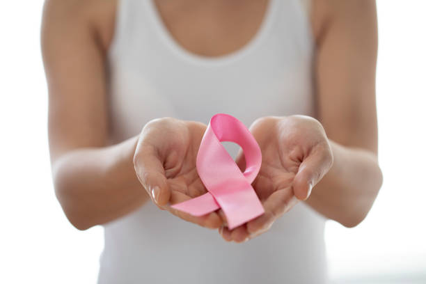 istock young woman showing pink ribbon 1440181103