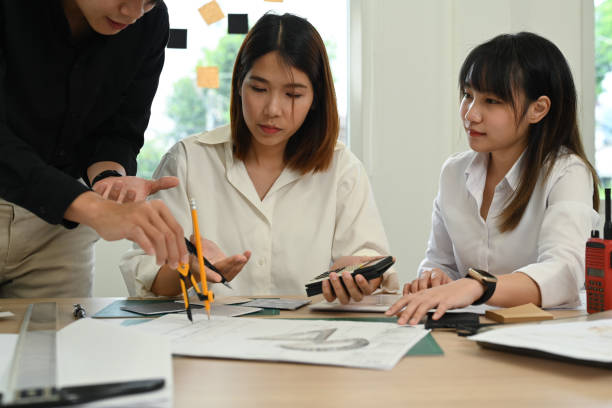 istock Group of young creative people working together of architectural project, collaborating with team leader at creative office. 1440181401