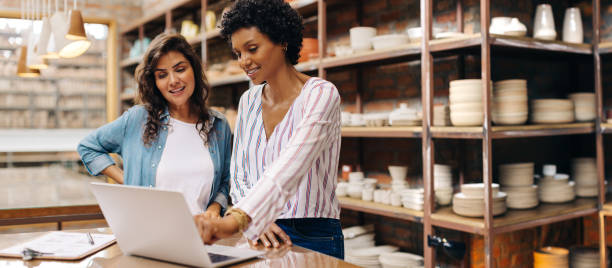 istock Young female ceramists using a laptop together in their store 1440182251