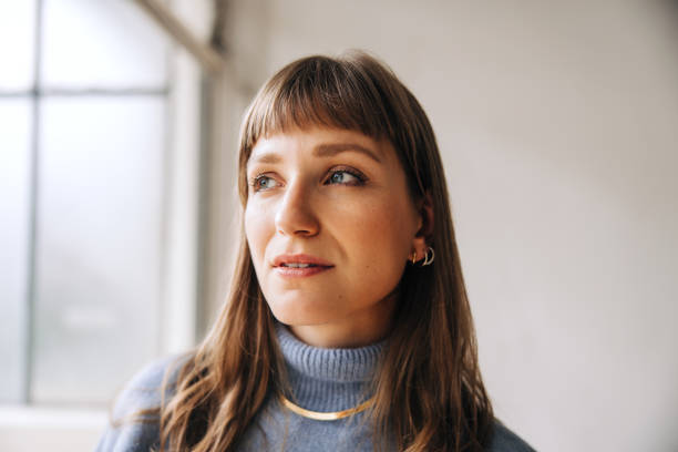 istock Pensive businesswoman looking away while standing in an office 1440182747