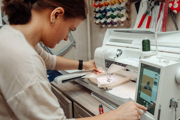istock A woman tailor makes embroidery on an embroidery machine in a home workshop.Mending clothes concept,small business.Selective focus,close-up. 1440184052