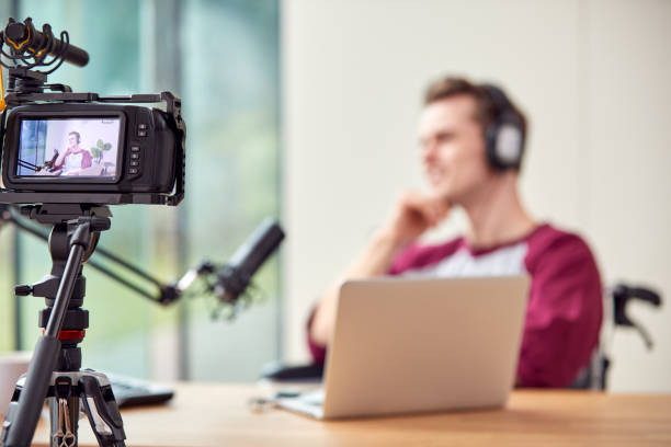 istock Male Vlogger With Laptop Recording Video At Home With Camera 1440184151