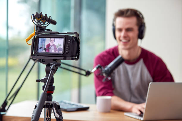 istock Male Vlogger With Laptop Recording Video At Home With Camera 1440184431