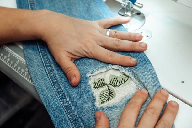 istock A woman mends jeans, sews a patch on a hole, hands close-up.Mending clothes concept,reusing old jeans 1440184478