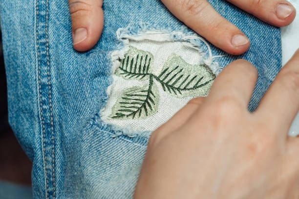 istock A woman mends jeans, sews a patch on a hole, hands close-up.Mending clothes concept,reusing old jeans 1440184485