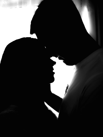silhouette of a happy couple man and woman at the window, couple in love silhouette at the window, touching noses