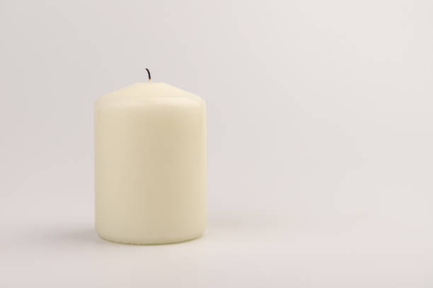 istock Burning white wax candles on white background. 1440186063