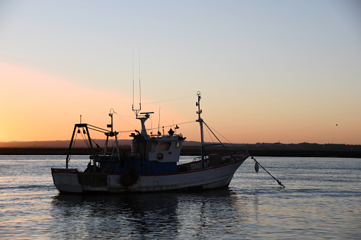 Fishing boat moored to the shore at sunset