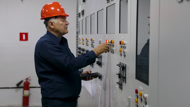 The engineer works and checks the state of electricity distribution in the substation room