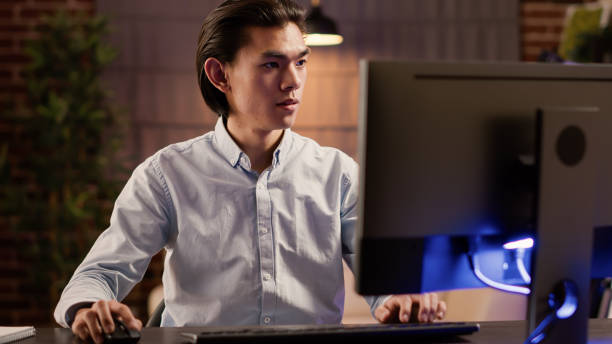 istock Focused asian man working on commercial report on website 1440193219