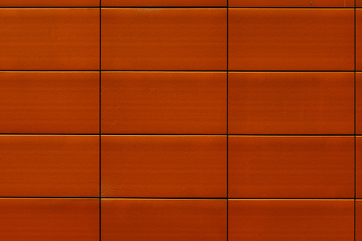 Section of a wall with orange tiles.