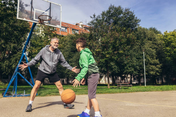 istock Mature man playing basketball with his son 1440193675