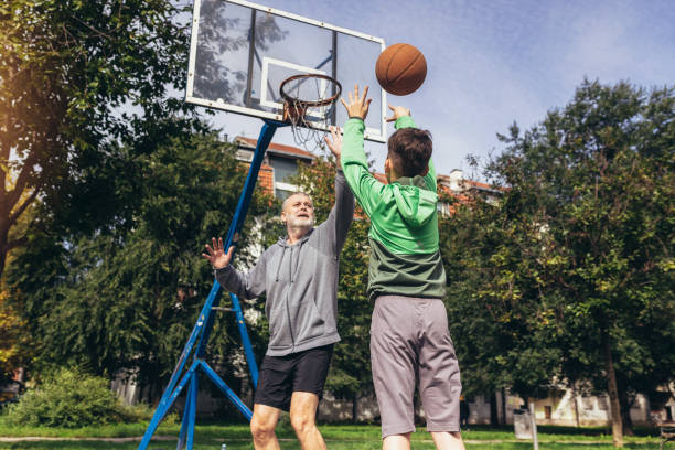 istock Mature man playing basketball with his son 1440193684