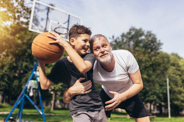 istock Mature man playing basketball with his son 1440193753