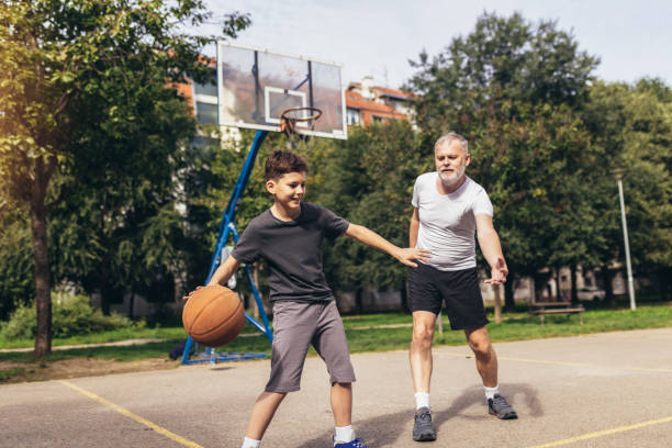 istock Mature man playing basketball with his son 1440193754