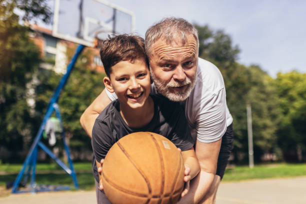 istock Mature man playing basketball with his son 1440193755
