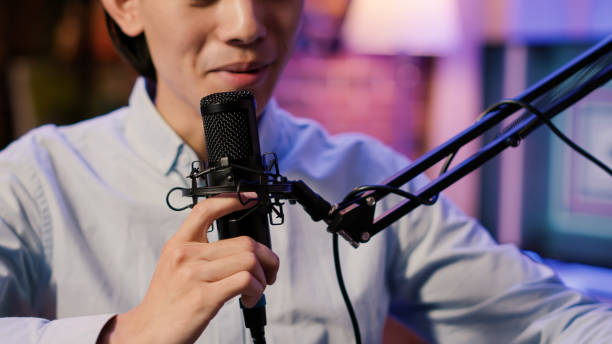 istock Internet vlogger recording podcast episode with microphone 1440193780