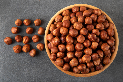 Bowl full of hazelnuts  on dark background
