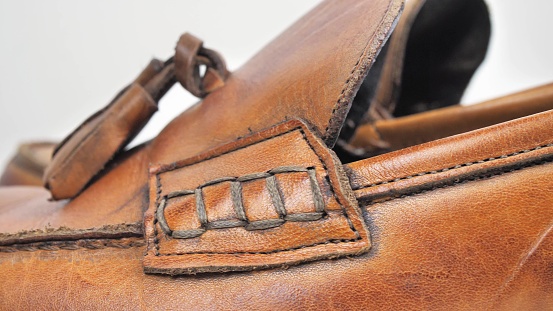 Front shot of brown leather shoes on floor next to bed