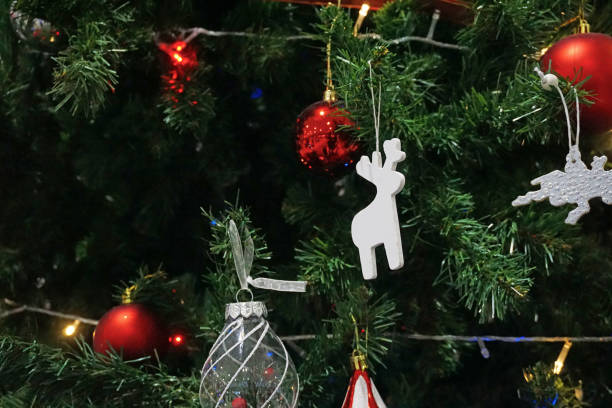 istock A white reindeer figurine is hanging on a green Christmas tree. 1440197573