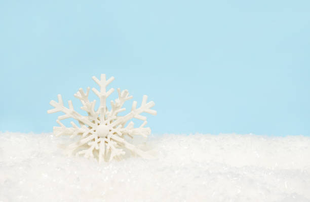 Beautiful decorative snowflake on white snow. blue background with space for text, greeting christmas card