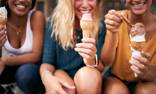 istock Three young woman eating ice cream cones close up 1440198846