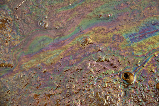 dirty rainbow surface of sea water, the concept of water pollution