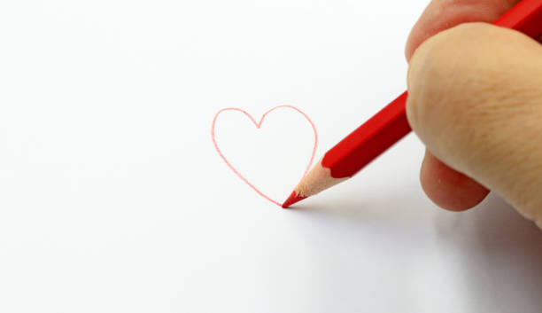 빨간 연필은 종이에 하트를 그립니다. 텍스트를 위한 공간 - pencil colors heart shape paper 뉴스 사진 이미지