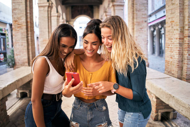 istock Three multiracial women using mobile phone outdoors. Youth and social media networking. 1440200646