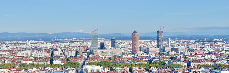 Panoramic cityscape with the Mount Blanc in the background and a newly construct tower in Lyon, France.
