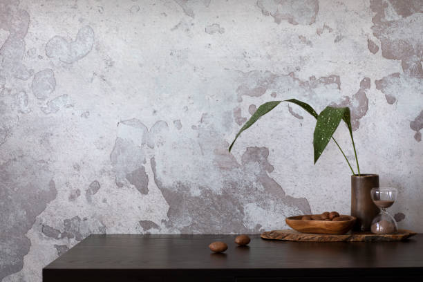 istock Concrete interior of home office with copy space. Black desk, image, lamp and office accessories. Grey concrete wall. Home decor. Template. 1440201559